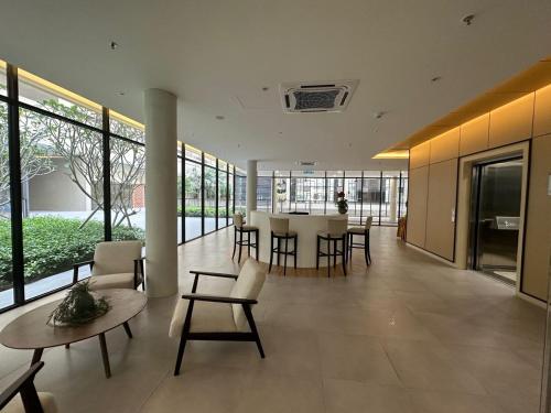 a lobby with tables and chairs in a building at Cozy Homely Studio @ Youth City Residence Nilai in Nilai