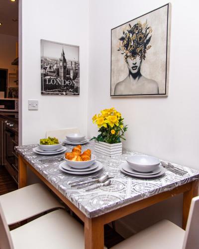 a dining room table with plates of food on it at Luxury 3 King Bed Apartment Quayside in Manchester