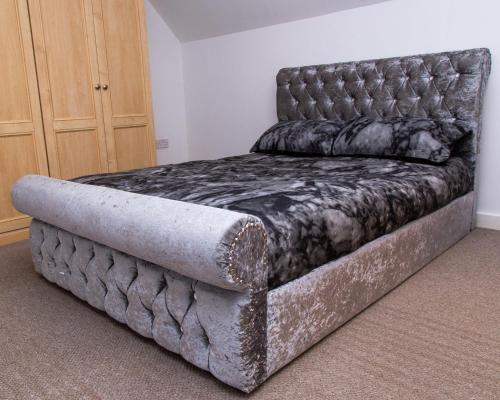 a large bed in a room with a tufted bedskirtspectspectspects at Luxury 3 King Bed Apartment Quayside in Manchester