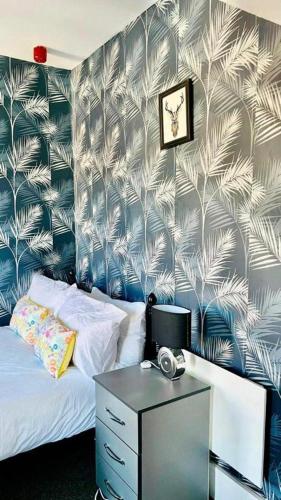 um quarto com uma cama e uma secretária com um relógio em Comfy 1 Bed Budget Apartment Near Blackpool City Centre 3 em Blackpool
