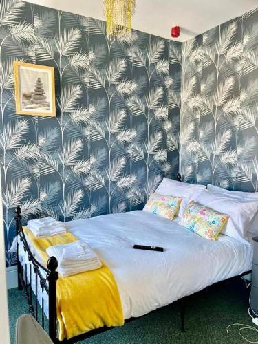 um quarto com uma cama com papel de parede azul e branco em Comfy 1 Bed Budget Apartment Near Blackpool City Centre 3 em Blackpool