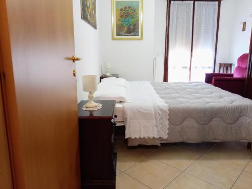 a bedroom with a bed and a table with a lamp at Appartamento Che Vista! Affittacamere in Mombaroccio