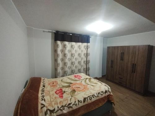 ein Schlafzimmer mit einem Bett und einer Kommode in der Unterkunft Departamento amplio in Huancayo
