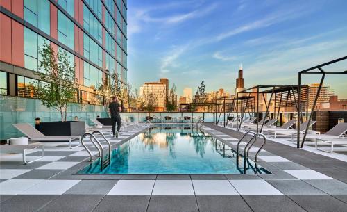 a person walking on top of a building with a pool at CoWorking Gym Pool Golfsim Steps from FultonMarket by Cloud9-160 in Chicago