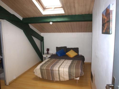 une chambre avec un lit dans un grenier dans l'établissement Parcieux.T2 meublé équipée, à Parcieux