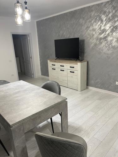 sala de estar con mesa y TV de pantalla plana en Liviu en Baia Mare