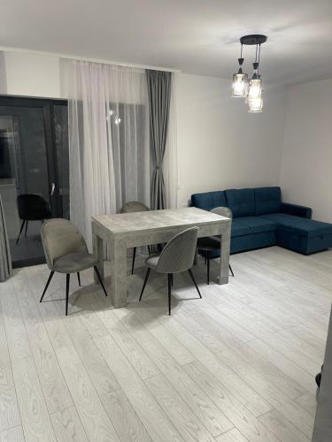 - un salon avec une table, des chaises et un canapé bleu dans l'établissement Liviu, à Baia Mare