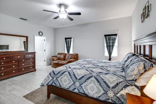 a bedroom with a bed and a dresser and a chair at Lovely Lehigh Acres Home with Lanai, Pool and Spa! in Lehigh Acres