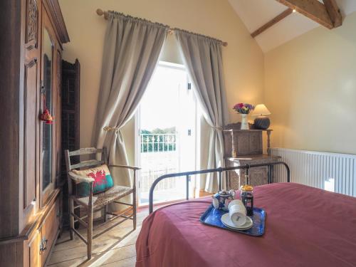 a bedroom with a bed with a table and a window at Dryslwyn Rhydlewis in Troedyraur