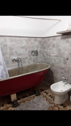 a bathroom with a bath tub and a toilet at Da zia Franca in Acate