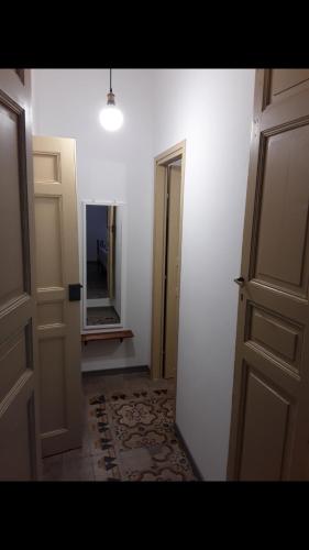 un pasillo vacío con una puerta abierta y un espejo en Da zia Franca en Acate