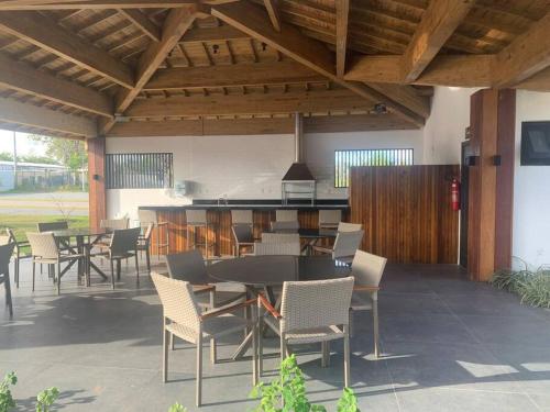 a patio with a table and chairs and a kitchen at Praia do Forte / Studio in Mata de Sao Joao