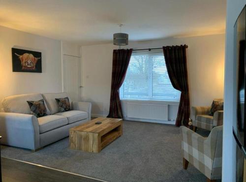 a living room with a couch and a coffee table at Kinneuchar Cottage - by Elie, Dog Friendly. in Kilconquhar