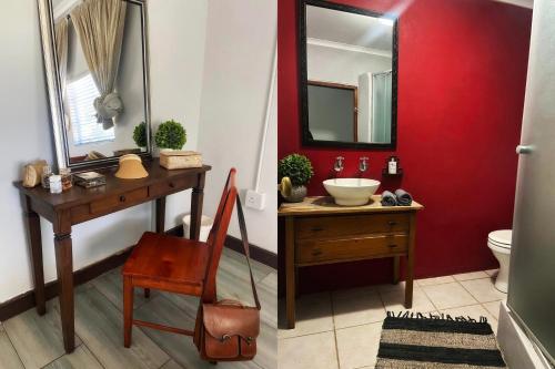 ein Badezimmer mit einer roten Wand, einem Waschbecken und einem Spiegel in der Unterkunft Bezalel Wine & Brandy Estate in Kanoneiland