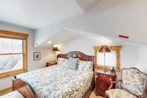 Un dormitorio con una cama, una silla y una ventana en Coyote Run 9, en Moab