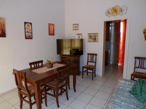 a dining room with a table and chairs and a television at Villa near the sea in full relaxation - large garden wi-fi in Fontane Bianche