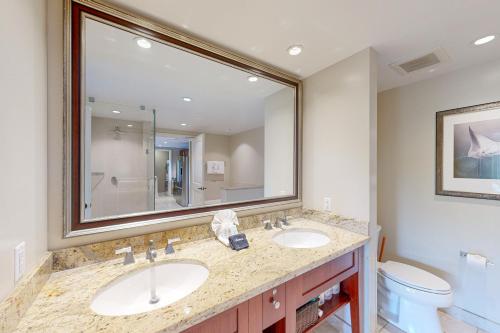 a bathroom with two sinks and a large mirror at Honua Kai - Konea 446 in Lahaina