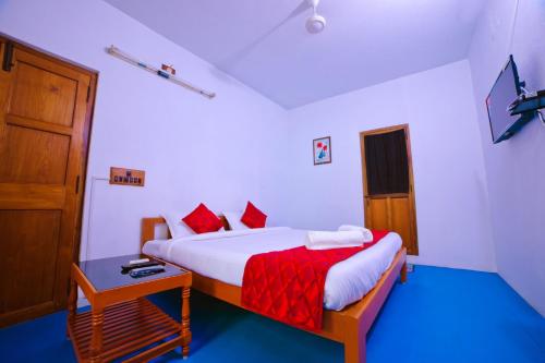 a bedroom with a bed with a red and white blanket at Sai White Villa Pondicherry in Puducherry