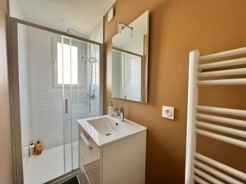 a bathroom with a sink and a shower and a mirror at Le 122 - Parking in Rodez