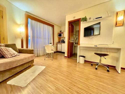 uma sala de estar com um sofá e uma secretária em 102 · Apto no batel c/ Ar condicionado em Curitiba