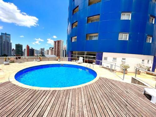 uma piscina em frente a um edifício azul em 102 · Apto no batel c/ Ar condicionado em Curitiba