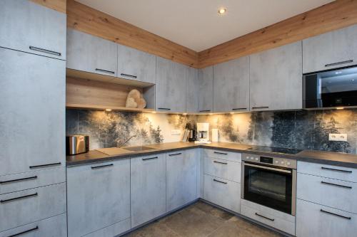 a kitchen with white cabinets and a microwave at Apart Lutz in Prutz