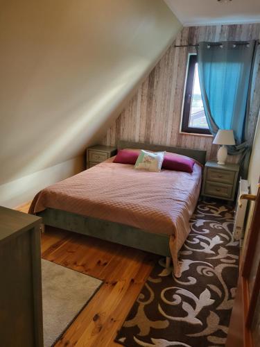 1 dormitorio con 1 cama con almohadas rosas en Dom Niebieski nad jeziorem Orzyskim, en Skomack Wielki