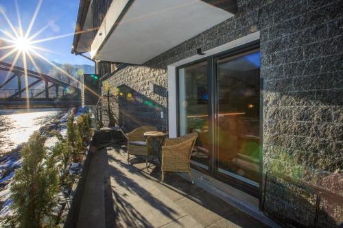 a balcony with two chairs and a window with the sun at Apart Lutz in Prutz