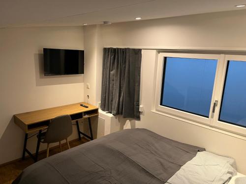 a bedroom with a bed and a desk and a window at Business City Lodge in Sankt Pölten