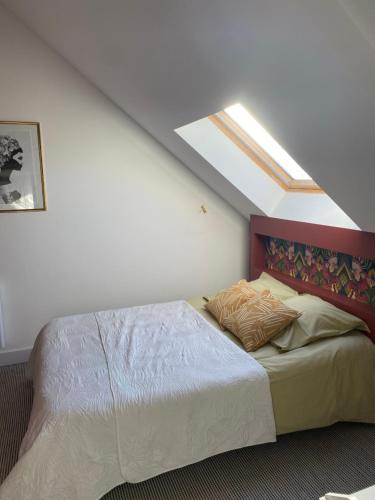 1 dormitorio con 1 cama grande y tragaluz en Maison au cœur d'une ancienne ferme à BAYEUX en Monceaux-en-Bessin
