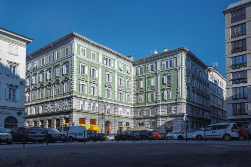 a large building with cars parked in front of it at Residence Piazza Giotti 8 in Trieste