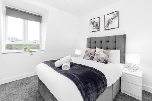 een witte slaapkamer met een groot bed en 2 ramen bij Stylish 2 Bedroom Apartment - Gated Parking & Balcony - Top Rated - 8MC in Birmingham