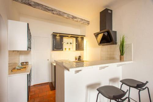 een keuken met een aanrecht en krukken in een kamer bij Charme du Vieil Antibes, au calme 2/4pers. in Antibes