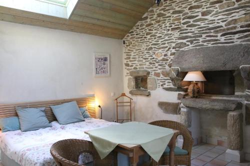 une chambre avec un lit et un mur en pierre dans l'établissement Domaine De Kéryel, à Plougonvelin