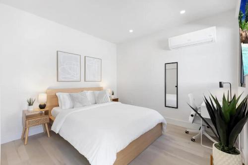 Dormitorio blanco con cama y maceta en Mango House en Dania Beach, en Dania Beach