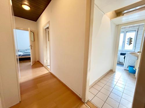 a hallway with white walls and a tile floor at StayRoom Apartments I Haven im Zentrum von Linz in Linz