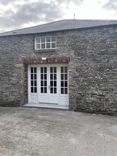 a brick building with a white door and a window at Rokeby cottage in Drogheda