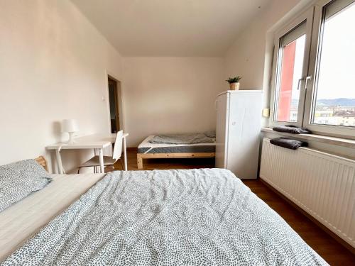 a bedroom with a bed and a table and a window at StayRoom Apartments I Haven im Zentrum von Linz in Linz