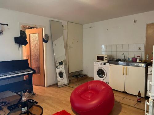 ミュルハイム・アン・デア・ルールにあるCHEAP SHARED LIVING & BEDROOM IN MULHEIM GERMANYの赤いオットマン付きのキッチン