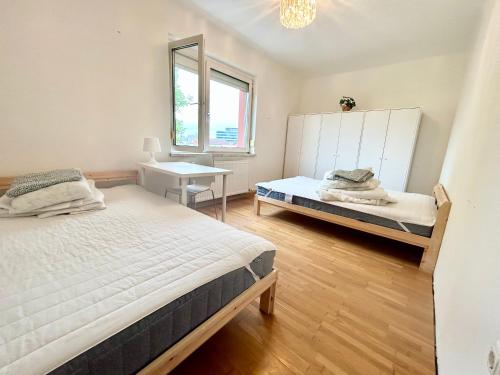 a bedroom with two beds and a mirror at StayRoom Apartments I Haven im Zentrum von Linz in Linz