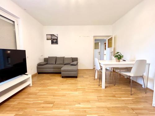 a living room with a couch and a dining room table at StayRoom Apartments I Haven im Zentrum von Linz in Linz