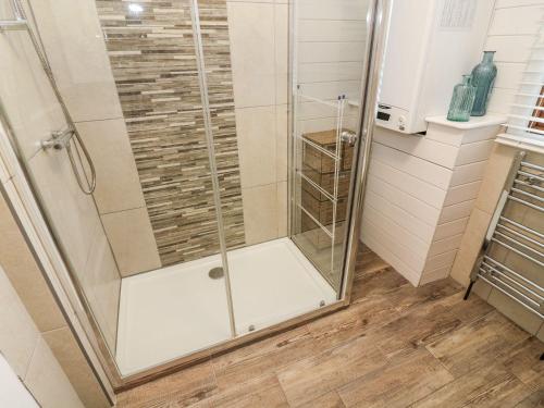 a shower with a glass door in a bathroom at Tree View Lodge in Windermere