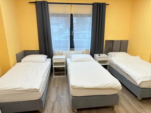 three beds in a room with a window at Ząbkowickie Centrum Sportu i Rekreacji Sp. z o. o. in Ząbkowice Śląskie