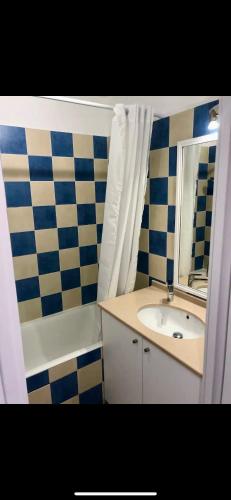 une salle de bain avec un lavabo, une baignoire et un miroir dans l'établissement Studio Port d'Hyères, à Hyères