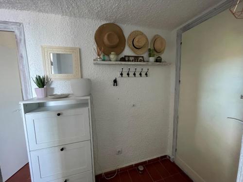 Zimmer mit weißen Schränken und Hüten an der Wand in der Unterkunft Villa Mediterraneo in Tossa de Mar