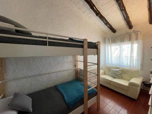 1 Schlafzimmer mit 2 Etagenbetten und einem Sofa in der Unterkunft Villa Mediterraneo in Tossa de Mar