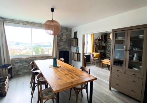 eine Küche und ein Esszimmer mit einem Holztisch in der Unterkunft Chez Célina - La Conciergerie. in Buxerolles