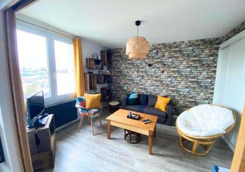 ein Wohnzimmer mit einem Sofa und einem Tisch in der Unterkunft Chez Célina - La Conciergerie. in Buxerolles