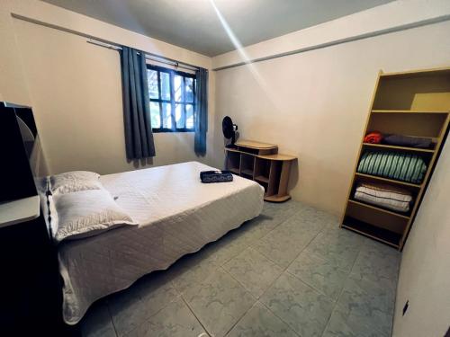 a bedroom with a bed and a book shelf at Casa Tamboril in Sao Jorge