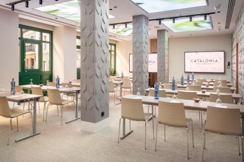 a conference room with tables and chairs and a presentation at Catalonia Atocha in Madrid